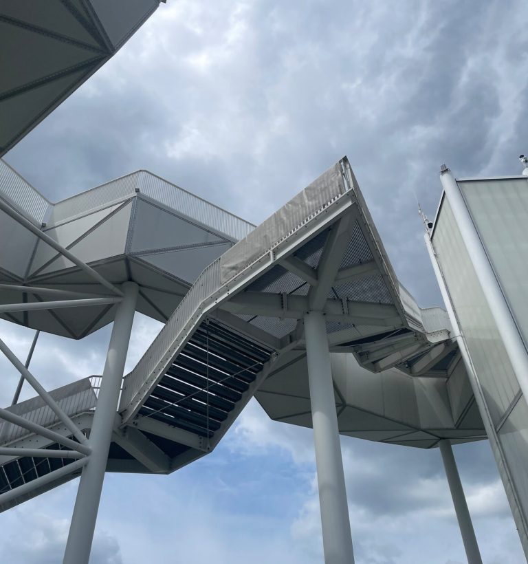 Seilbahn der Gärten der Welt auf dem Kienberg Blick auf die Seilbahn der Gärten der Welt, umgeben von Bäumen und bewölktem Himmel auf dem Kienberg.